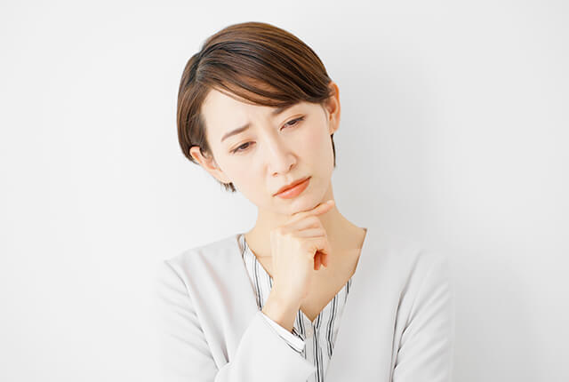 首をかしげて悩む女性