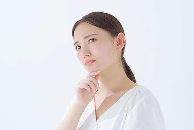 首をかしげて悩む女性