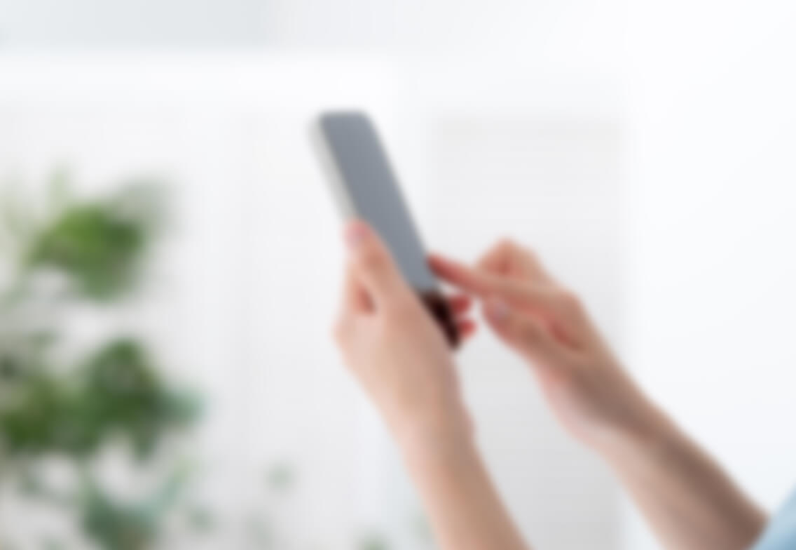 スマートフォントでWEB予約を行う女性のイメージ